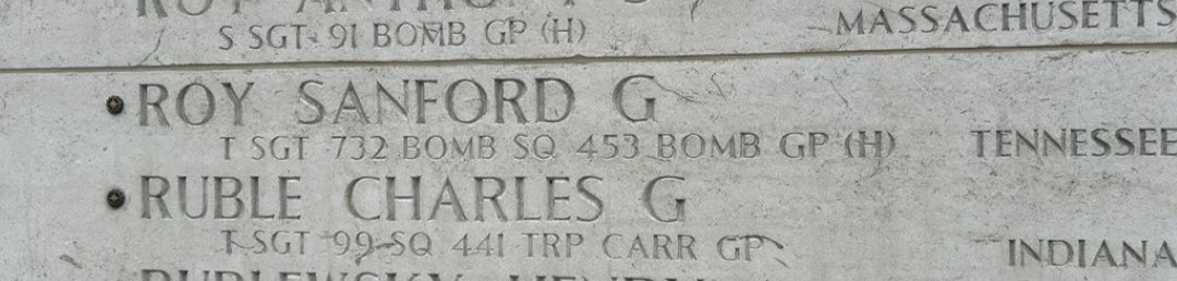 A bronze rosette is placed next to the name of Sanford Roy on the Wall of the Missing