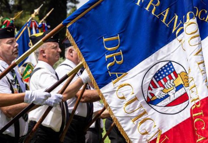 Flag bearers from French associations line the walk at Rhone American Cemeteryq