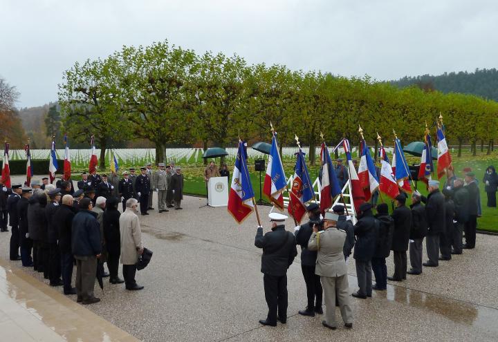 Attendees stand around the podium, listening as remarks are delivered.