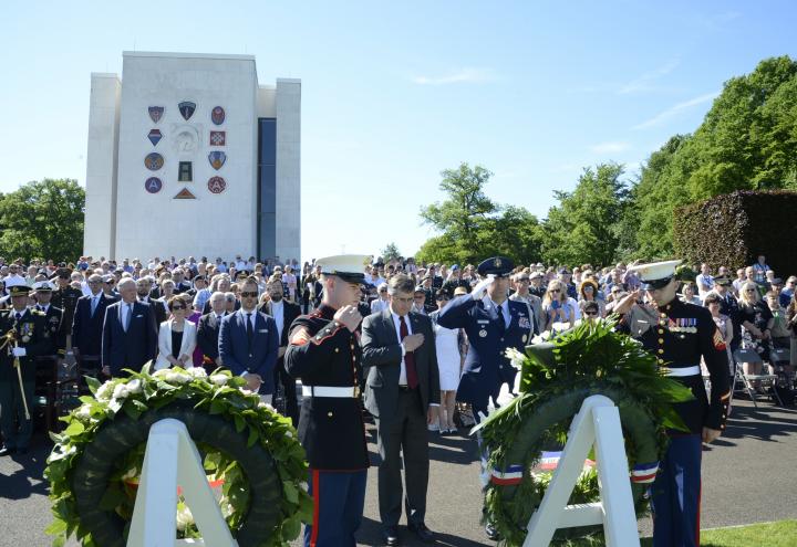 Men in uniform salute after the wreath is laid.