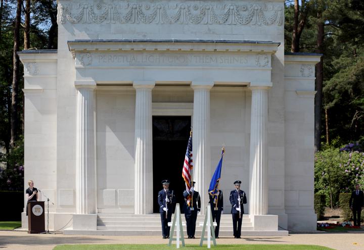 A U.S. Color Guard stands with flags and rifles outside the chapel.