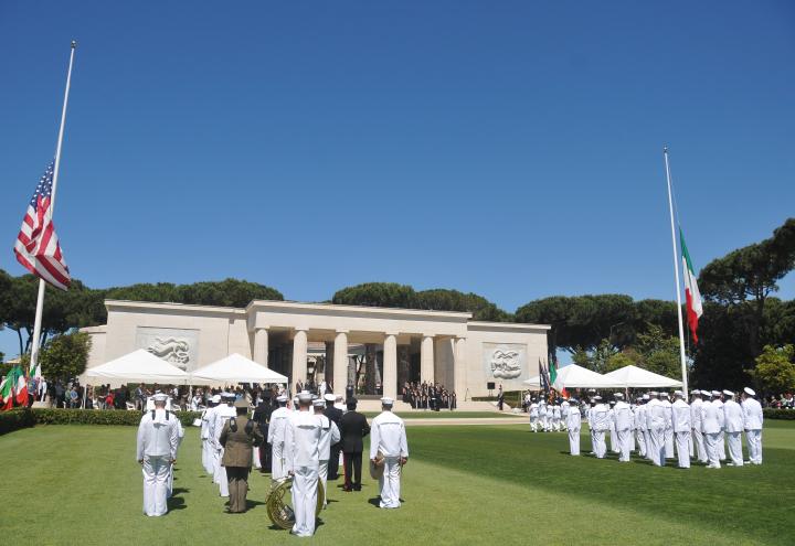 Attendees and participants stand during the ceremony. 