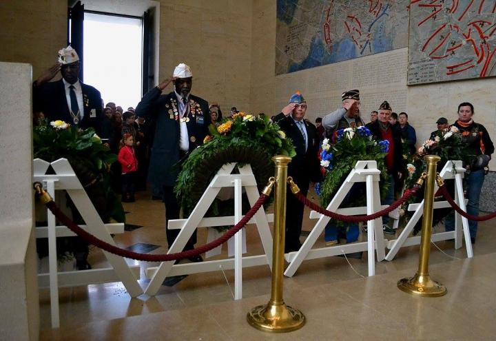 Men salute after laying wreaths in the chapel. 