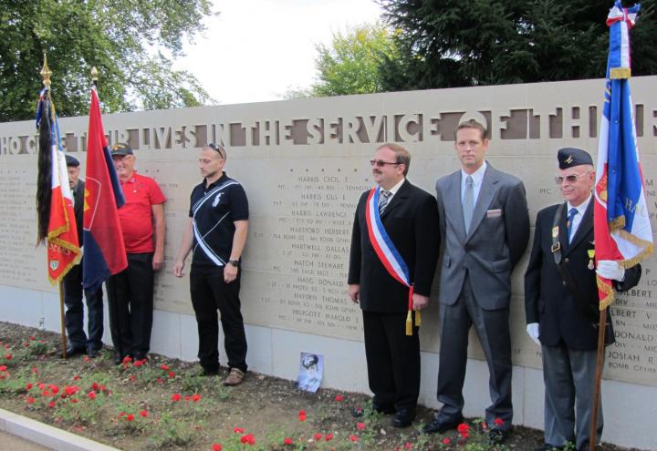 Ceremony participants stand in front of the Wall of the Missing. 