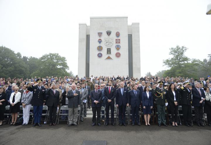 A large crowd of people stand in front of the chapel during the ceremony.