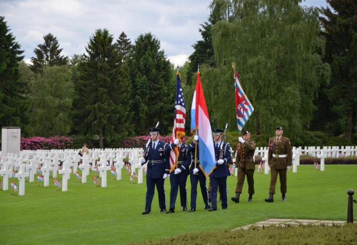 Members of the military march in with flags. 