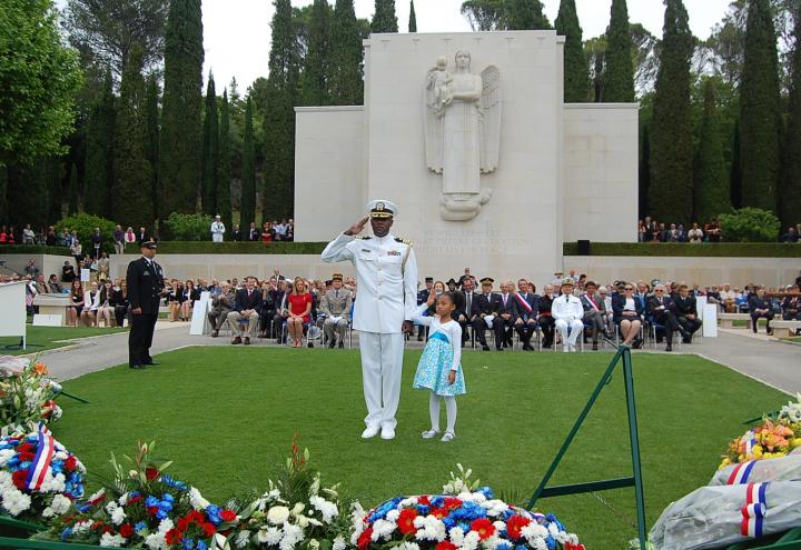 Man in uniform and little girl salute. 