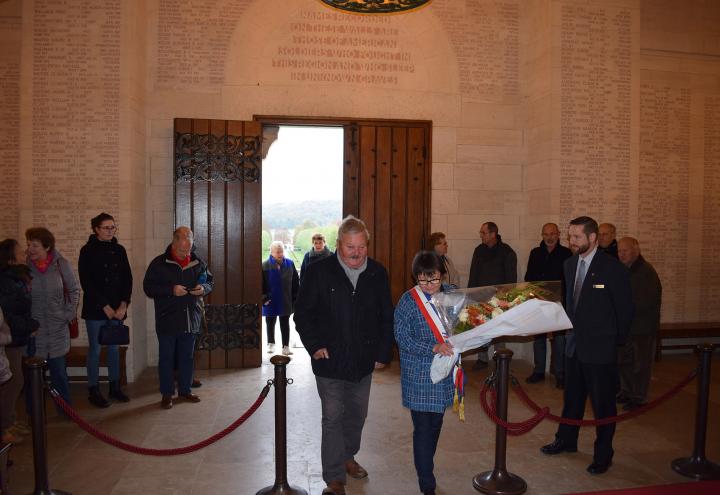 A man and woman prepare to lay flowers in the chapel. 