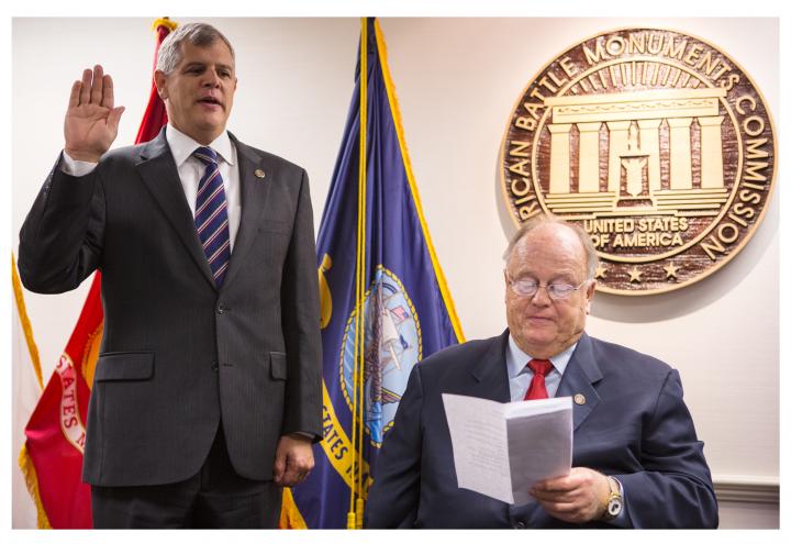 Dalessandro raises right hand for swearing in by Cleland. 