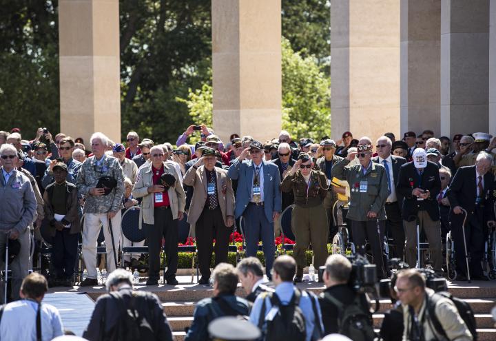 WWII veterans stand during the ceremony and salute. 