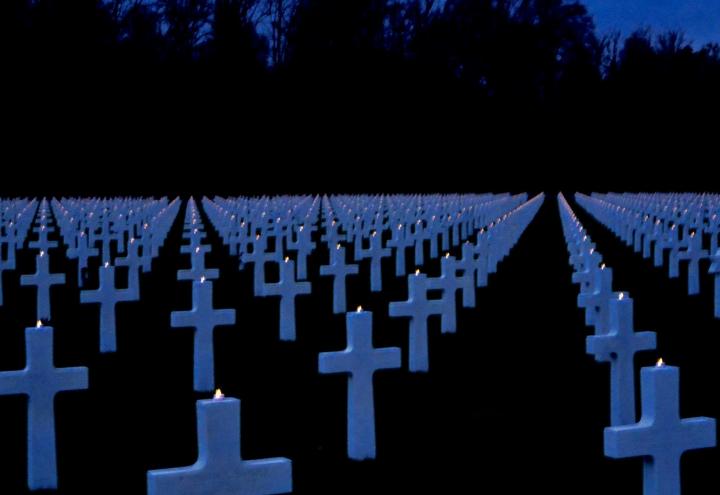 Small candles glow atop the marble headstones. 