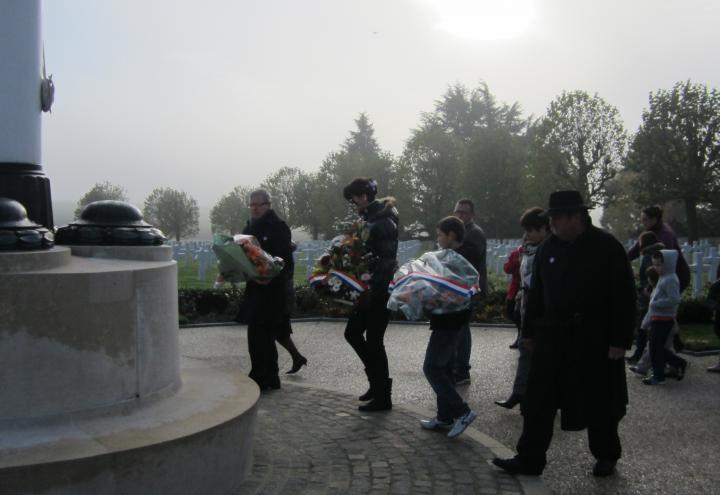 Participants prepare to lay floral wreaths at base of flag pole. 