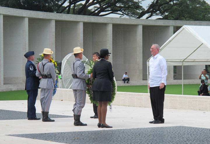 Members of the military carry floral wreaths. 