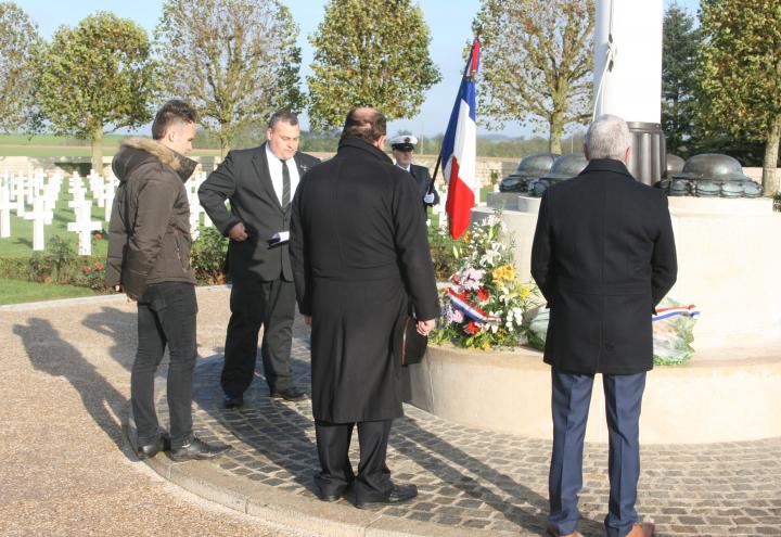 Ceremony participants stand near the flagpole. 