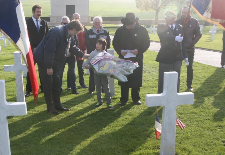 Attendees gather near a gravesite to lay flowers. 