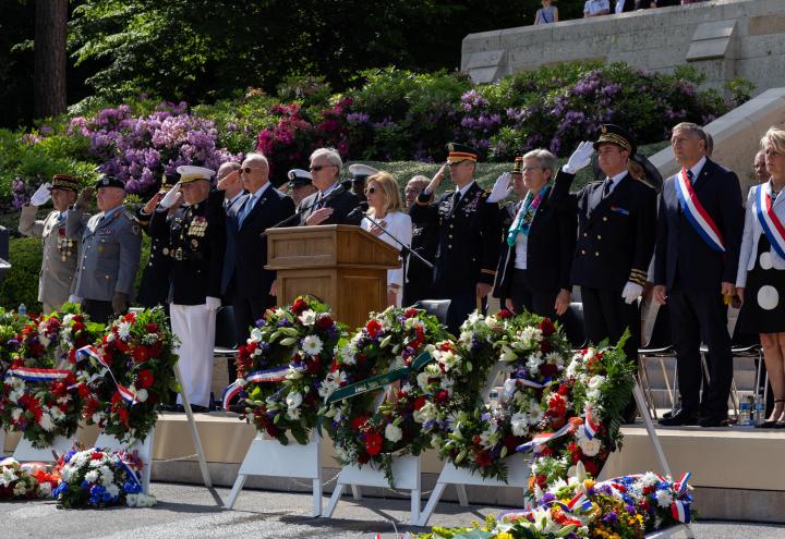 Men and women in the official party stand during the ceremony. 