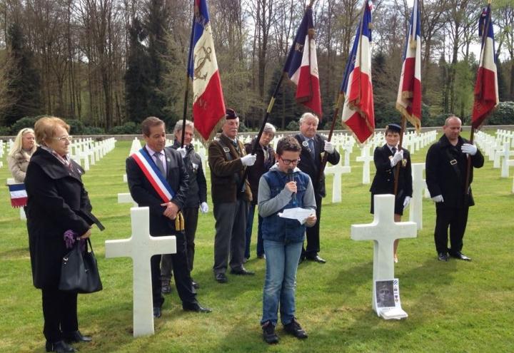 Ceremony participants stand around one of the adopted headstones. 