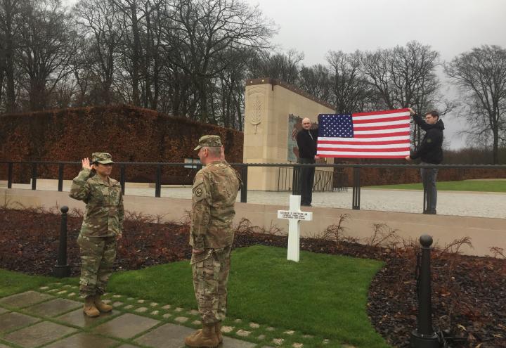 SSgt. Sanches, in uniform, raises her right hand while she re-enlists. 