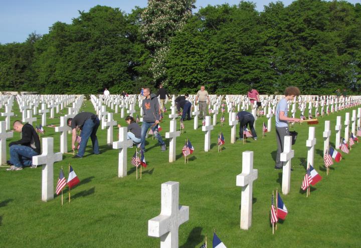 Volunteers place American and French flags in front of every headstone. 