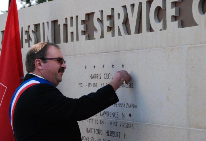 Mayor Herzog affixes the rosette to the Wall of the Missing. 