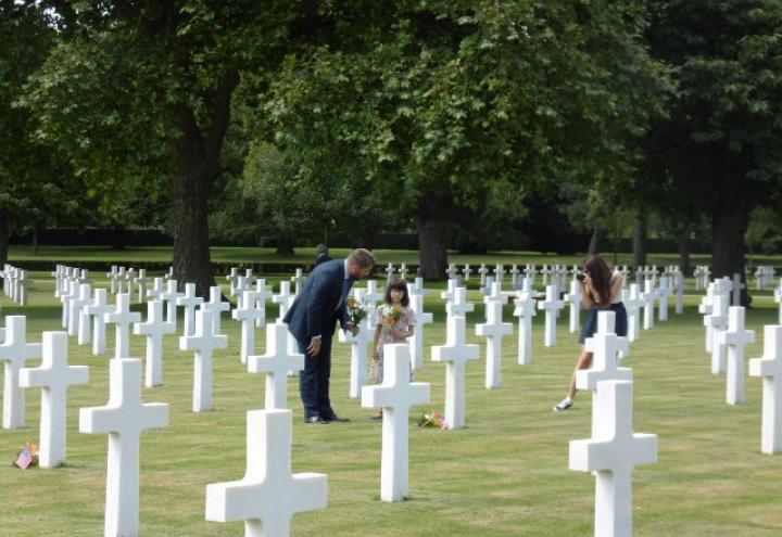 The mayor and a child lay flowers in the plot area. 