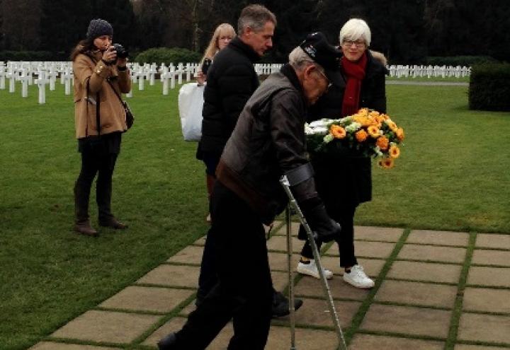 Izumi walks towards Patton's headstone to lay a wreath. 