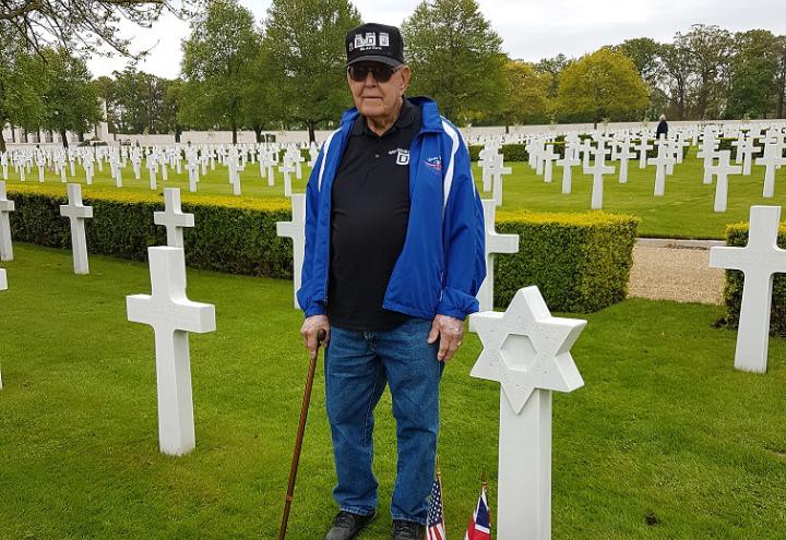 Urice stands next to his friend's headstone. 