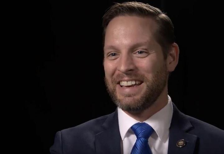 Shane Williams sitting in front of a black backdrop. 