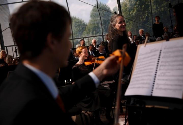 Musicians sit with their music and instruments before the concert begins. 