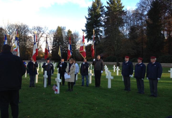 Flag bearers stand behind the one of the adopted graves during the ceremony.