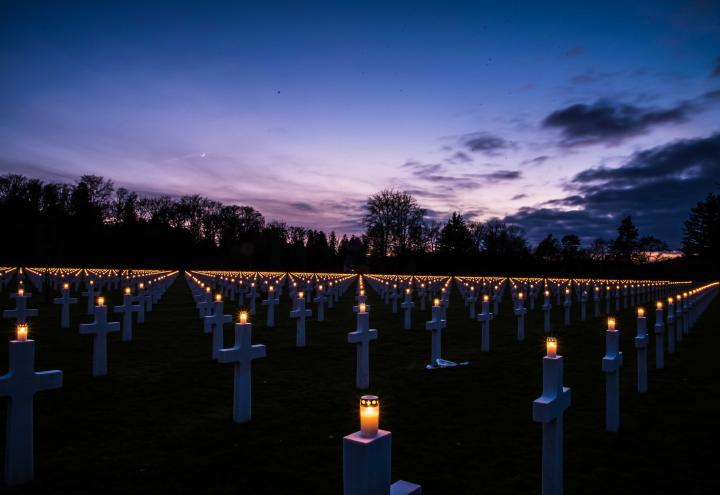 Lit candles can be seen on top of the headstone. 