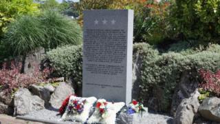 Square floral wreaths sit at the base of the new monument. 