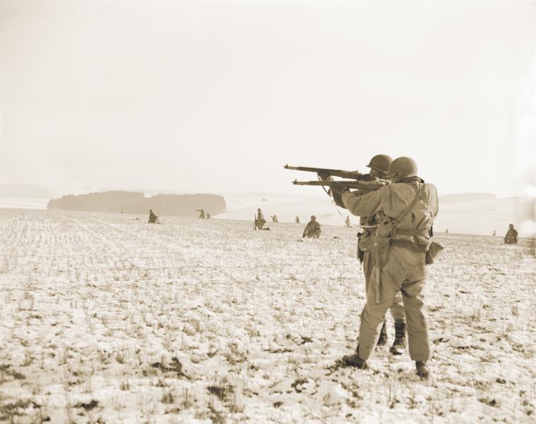 U.S. soldiers fire on German forces encircling Bastogne.