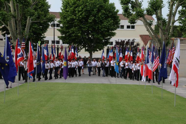 Men and women march in during the ceremony, each bearing a flag. 