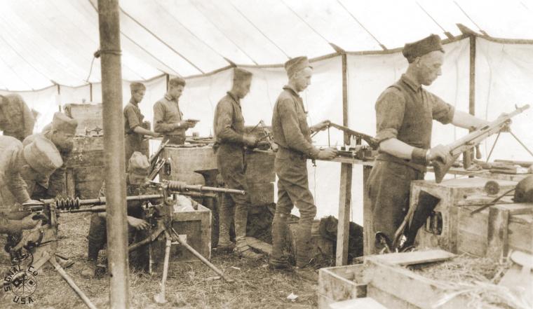 Soldiers of the 42nd Division's mobile ordnance shop repair machine guns for service.